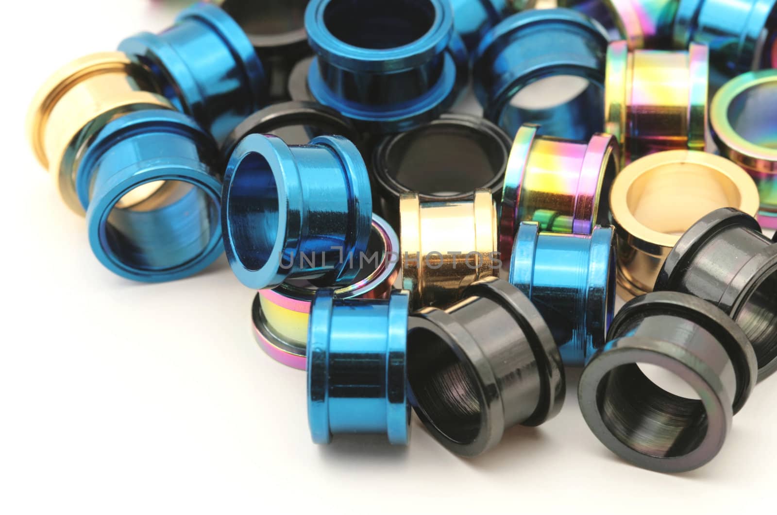 A big pile of colorful titanium screw on flesh tunnels. These are used in stretched ear lobes.