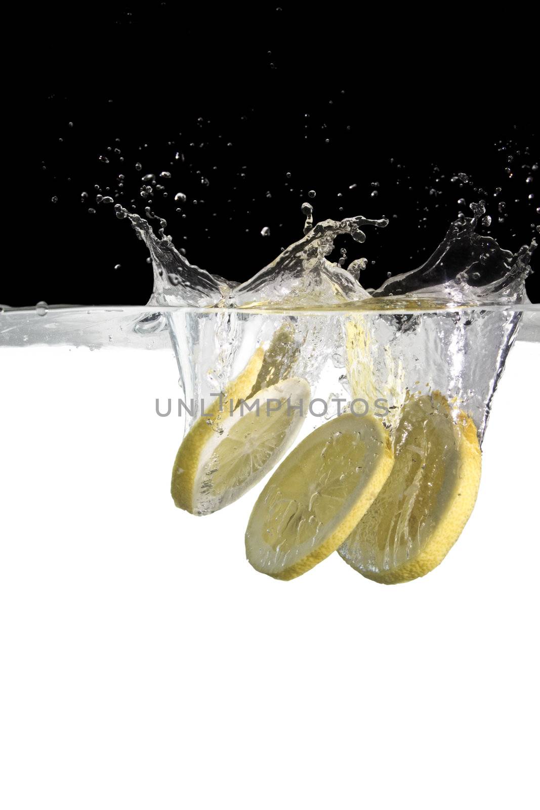 some lemon slices thrown in water with black and white background