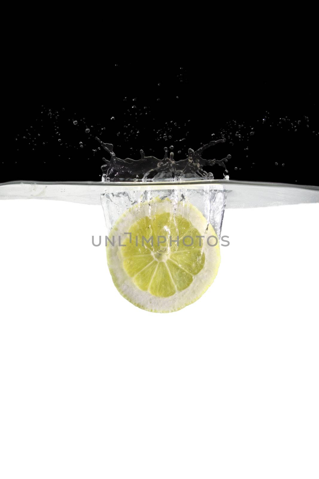 one slice of lemon thrown in water with black and white background