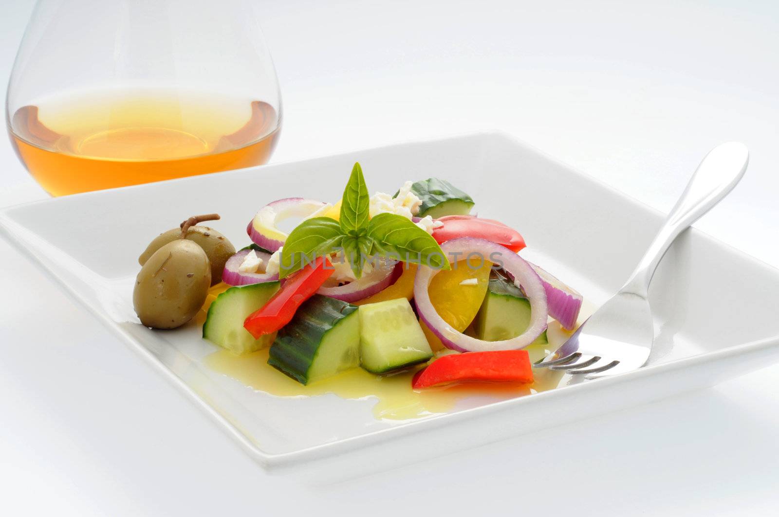 Delicious fresh greek salad with white wine.