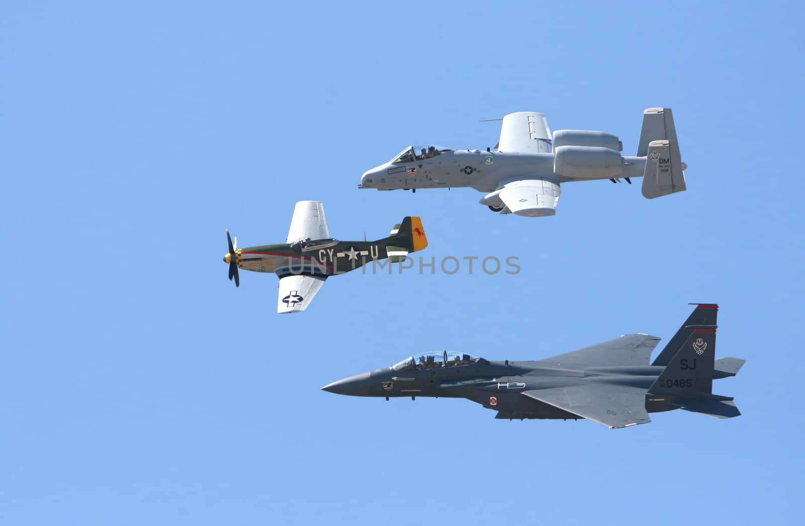 Three military aircraft flying through a blue sky