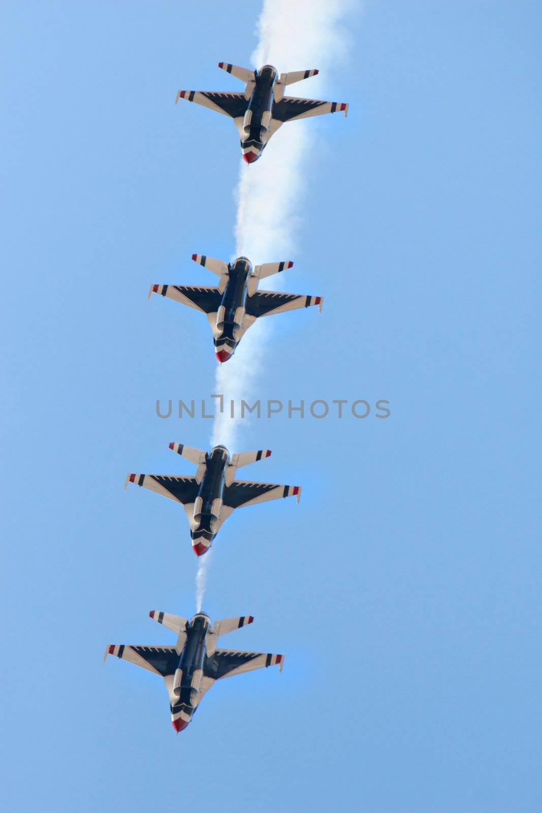 Four fighter jets flying in formation against a clear blue sky