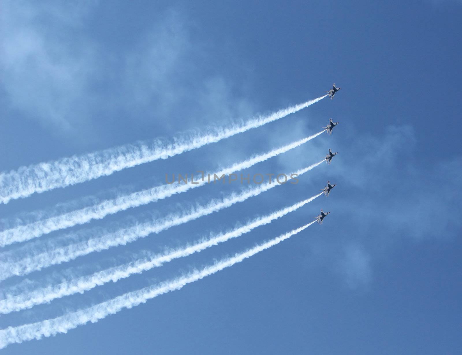 Five fighter jets flying in formation against a clear blue sky