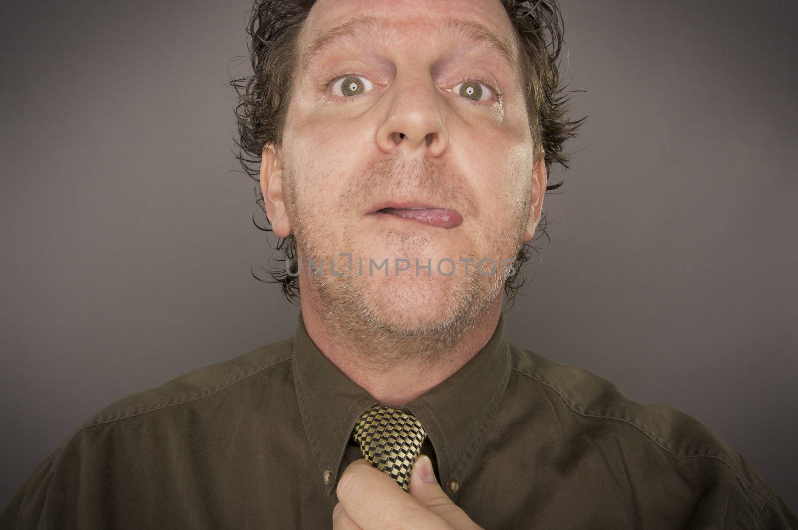 Man Concentrating Fixing Tie on a Grey Background