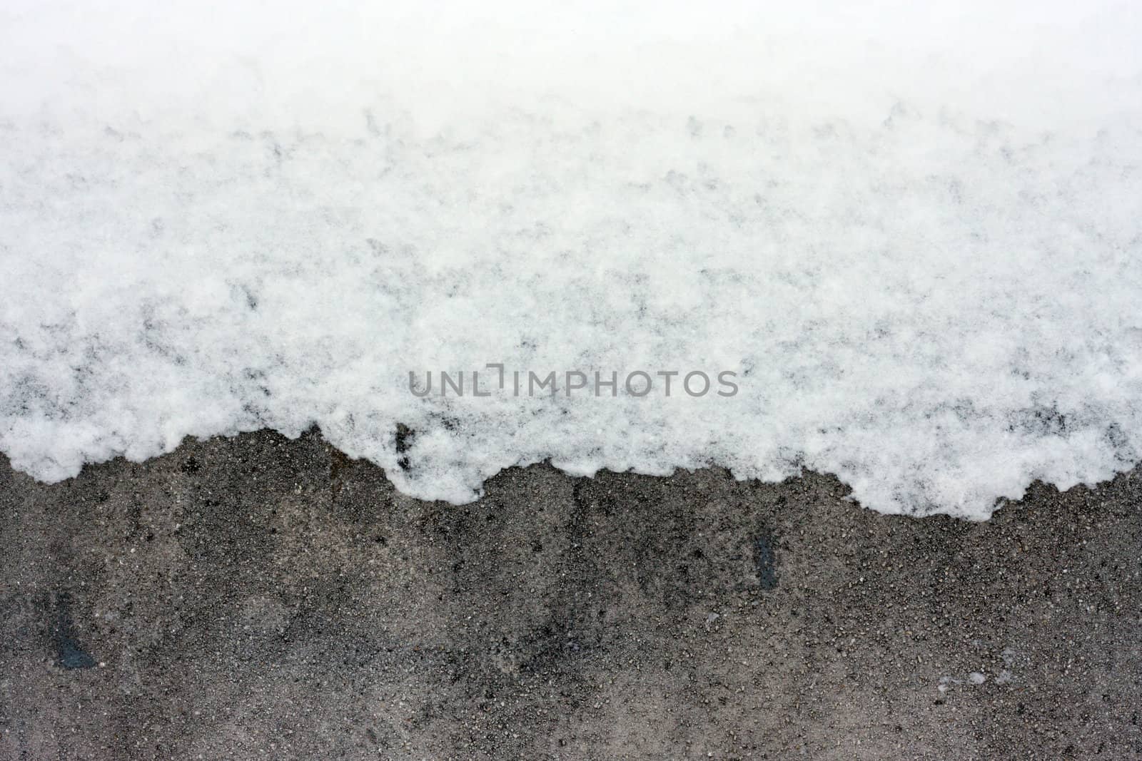 Snow covering part of a concrete wall