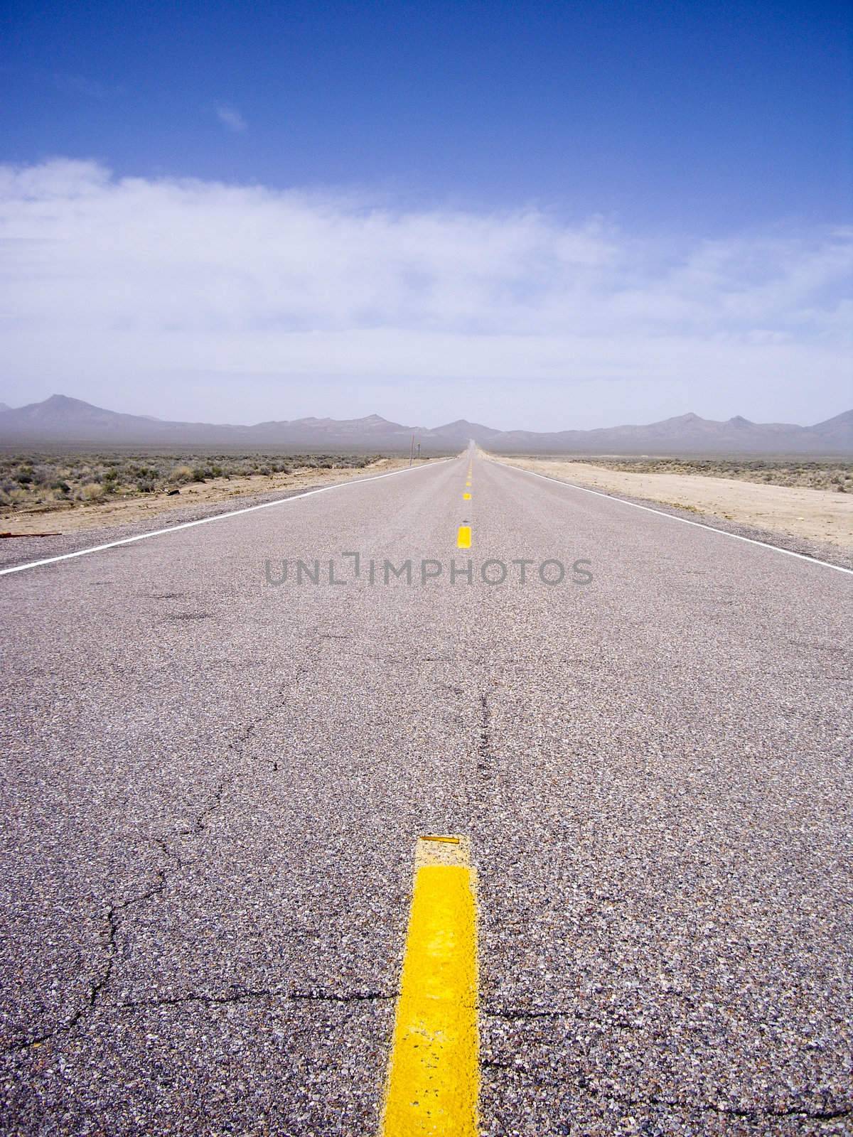 Yellow stripes lead the way on empty desert highway