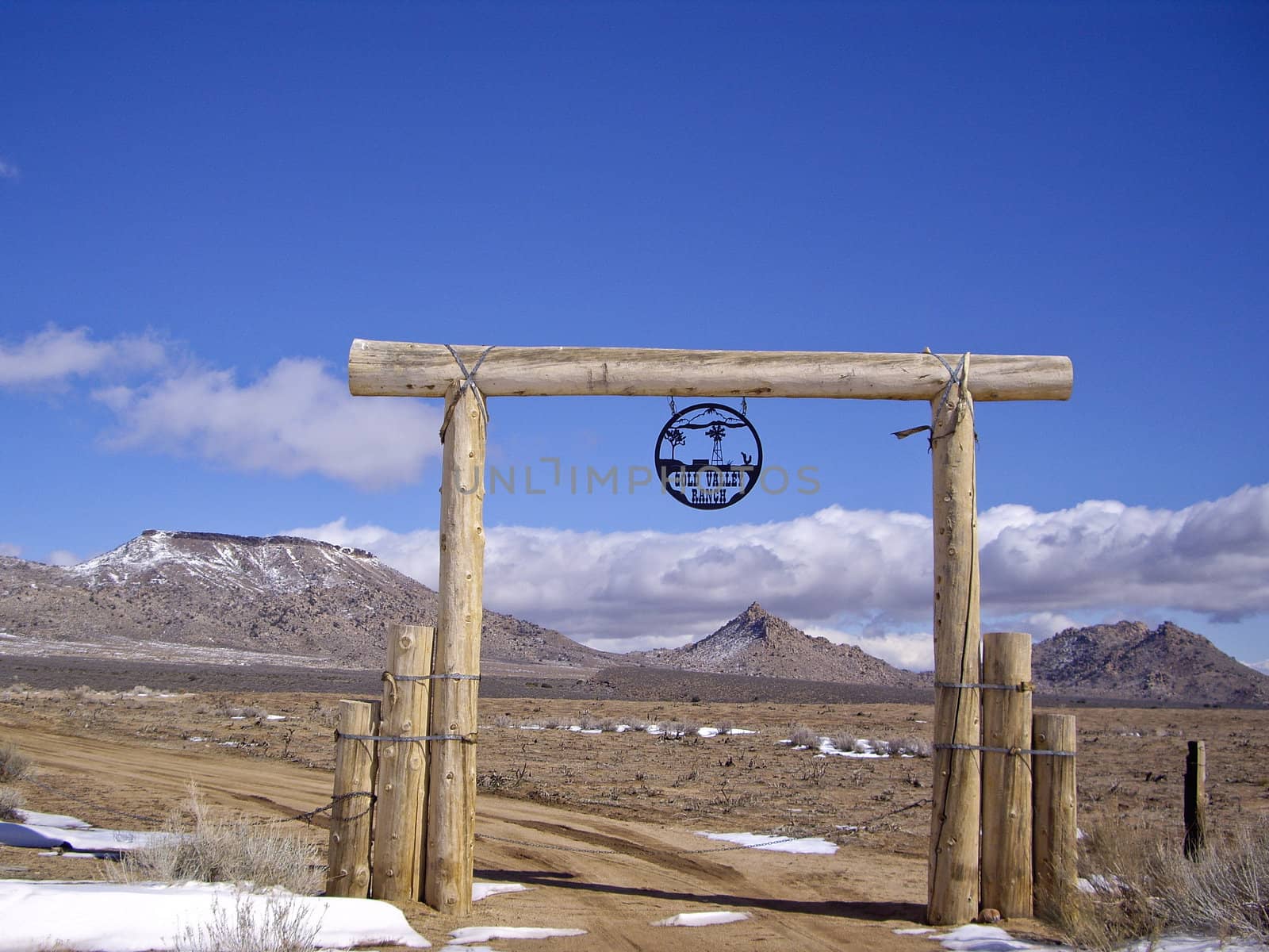 Desert ranch entrance with snowy vista
