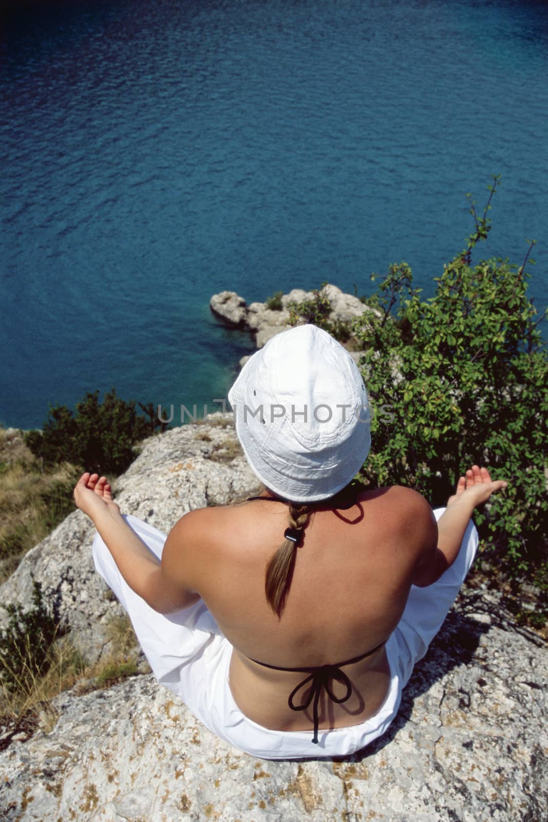 Woman outdoors doing yoga on cliff  by MonkeyBusiness