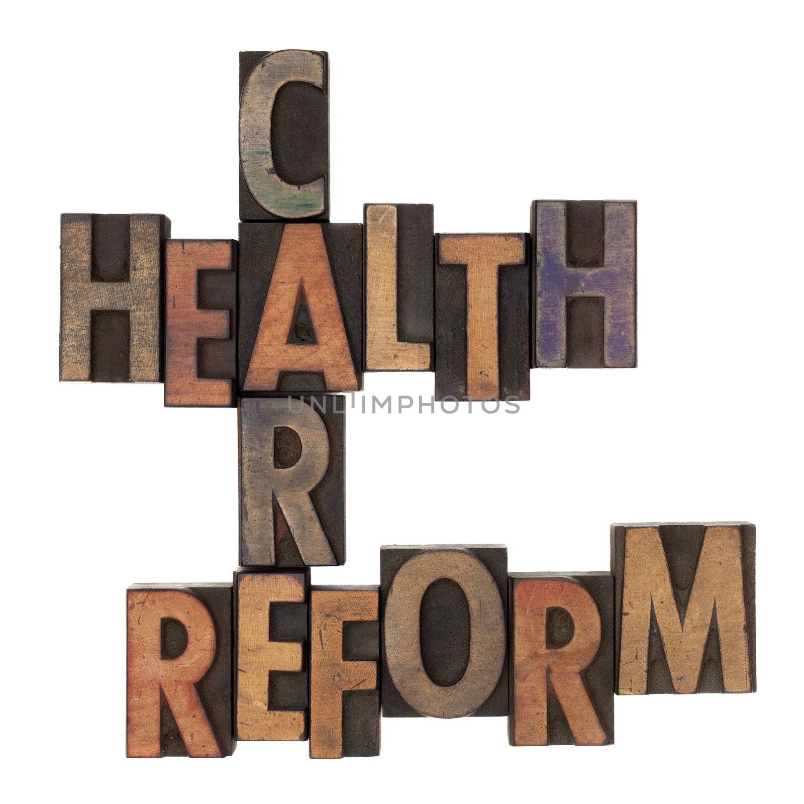 health care reform crossword in vintage wooden letterpress types stained in ink, isolated on white