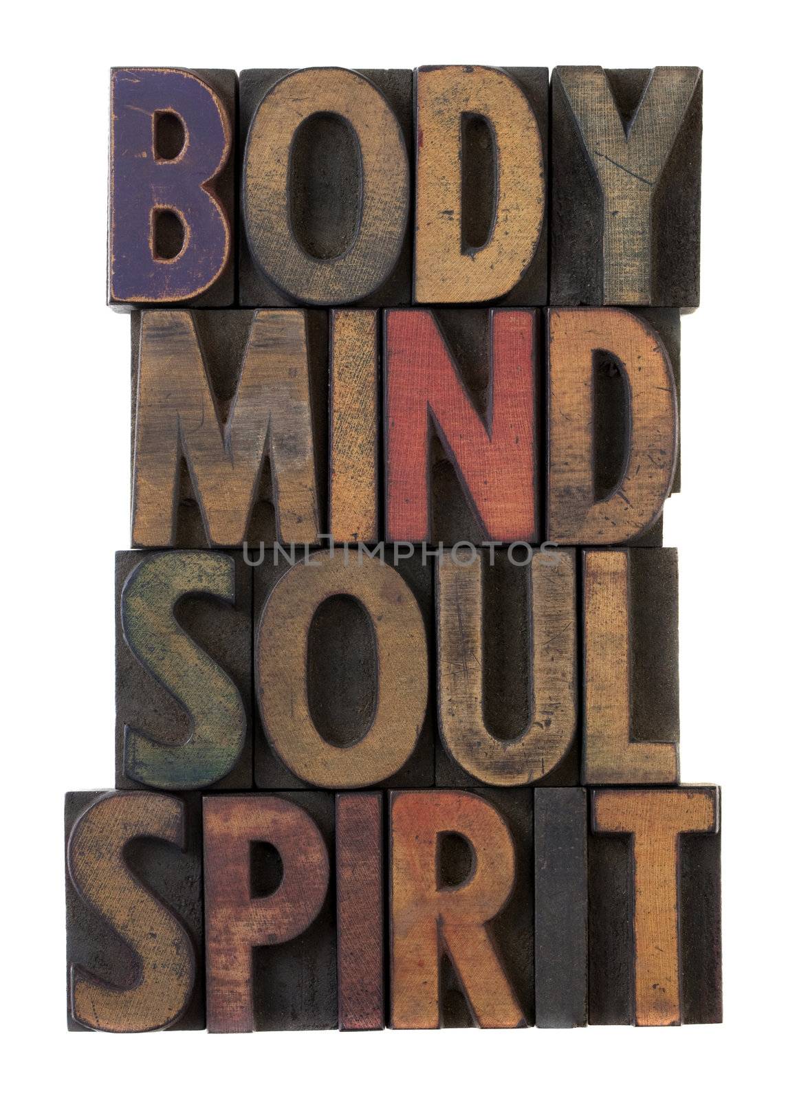 body, mind, soul, spirit in vintage wooden letterpress types, stained by ink in different colors, isolated on white