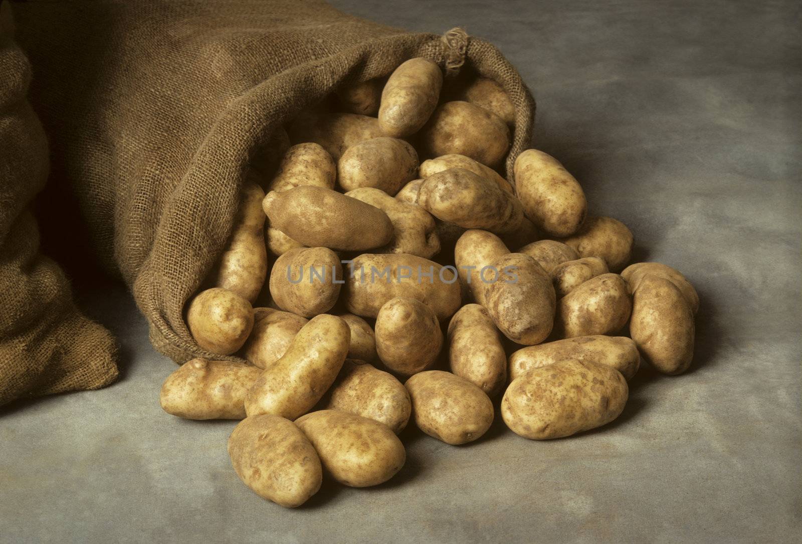 Spilled burlap sack of potatoes by Balefire9