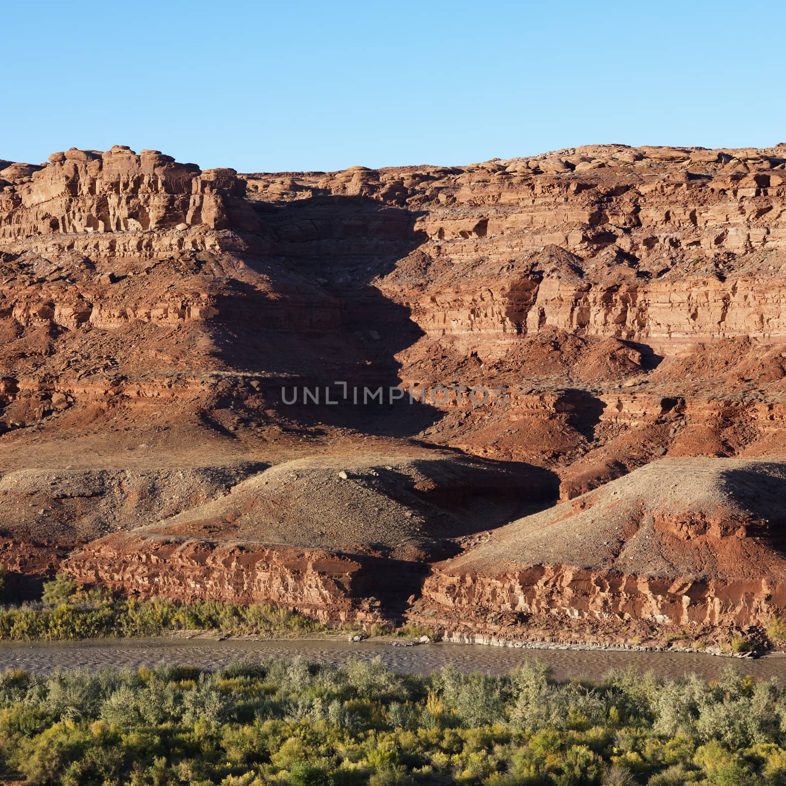 Small river running along rocky desert cliffs in Utah.