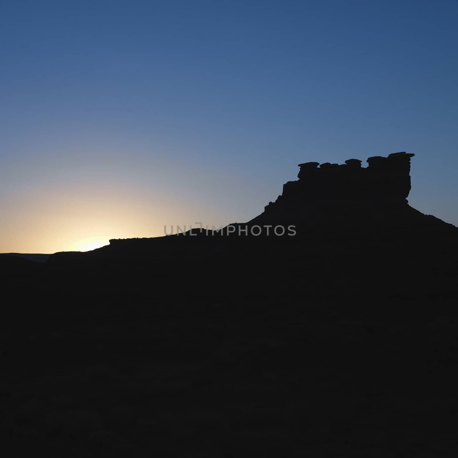 Silhouette of Garden of the Gods rock formation at dusk in Monument Valley, Utah.