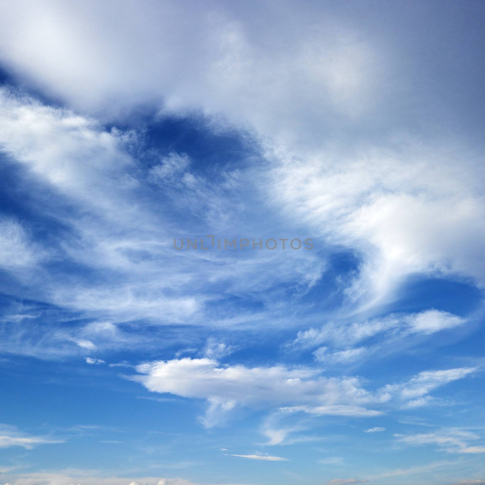 Wispy cloud formations against clear blue sky.