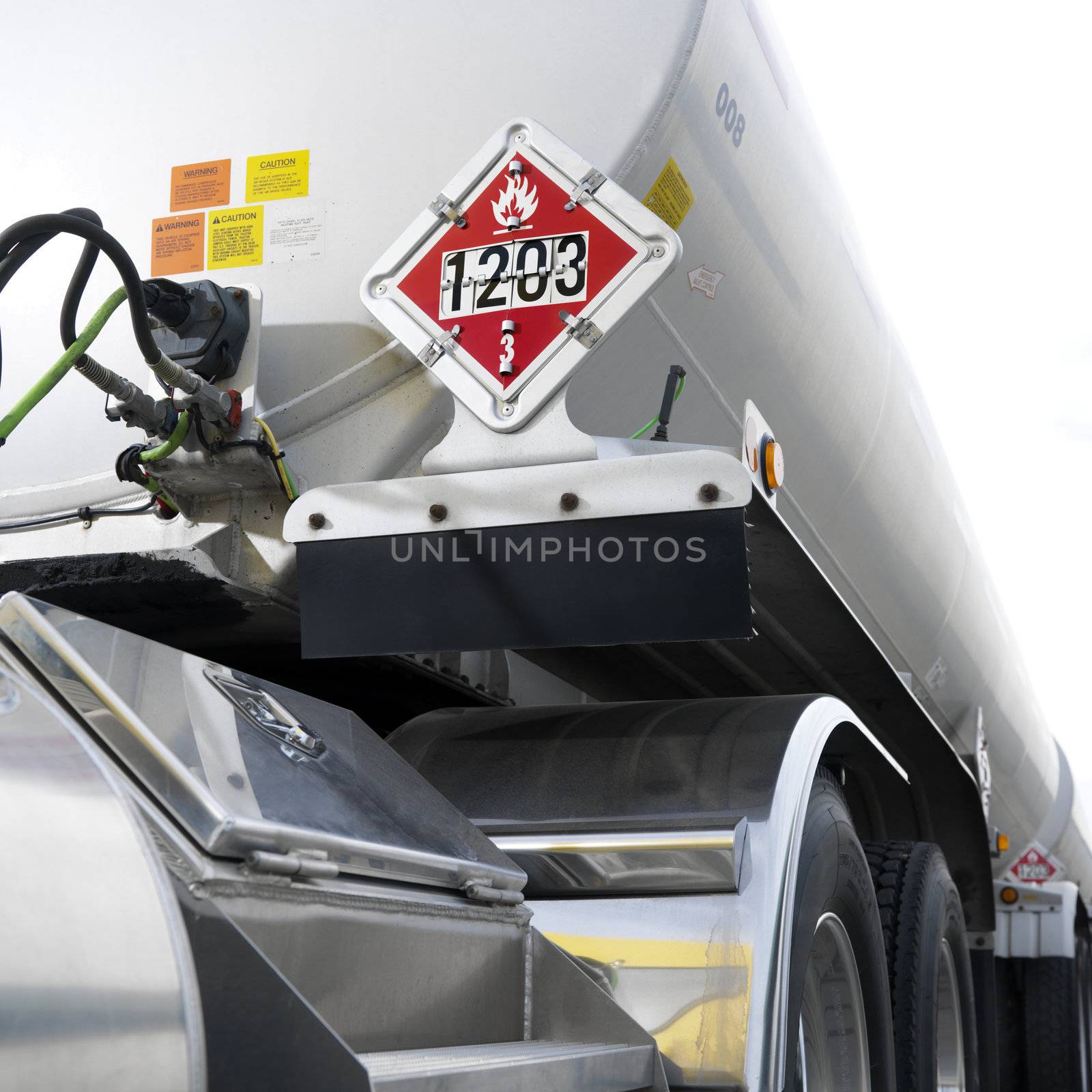 Fuel tank truck with flammable warning sign on back.