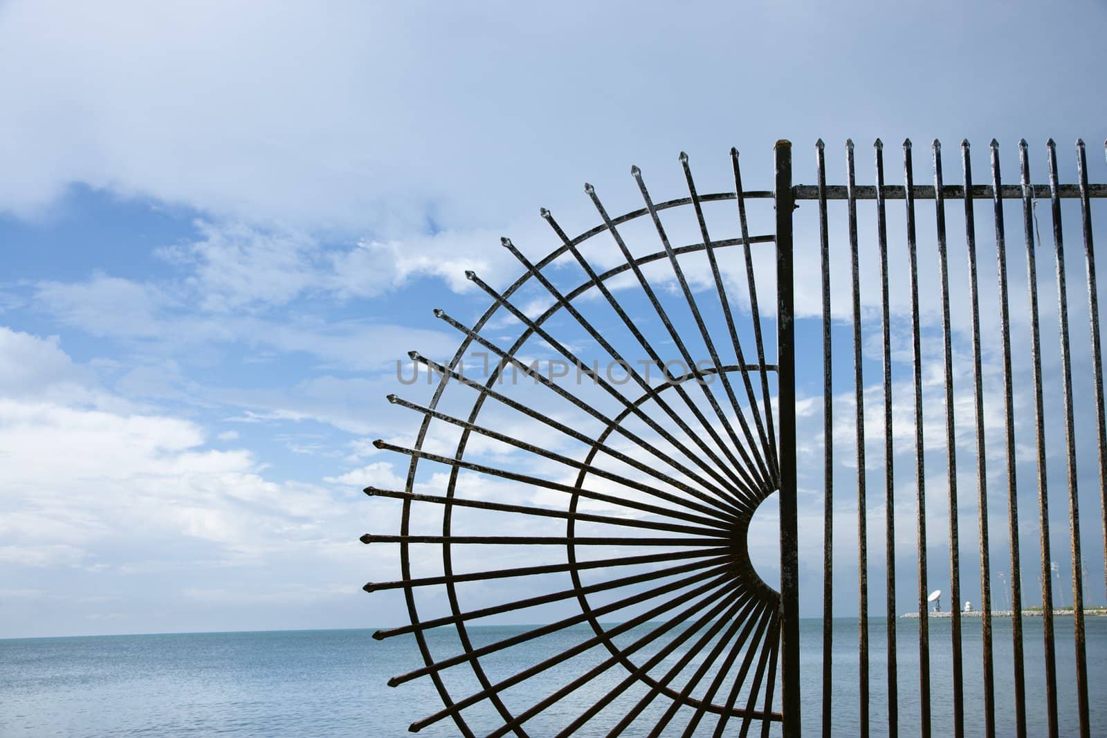 Decorative wrought iron fence at the edge of the sea.
