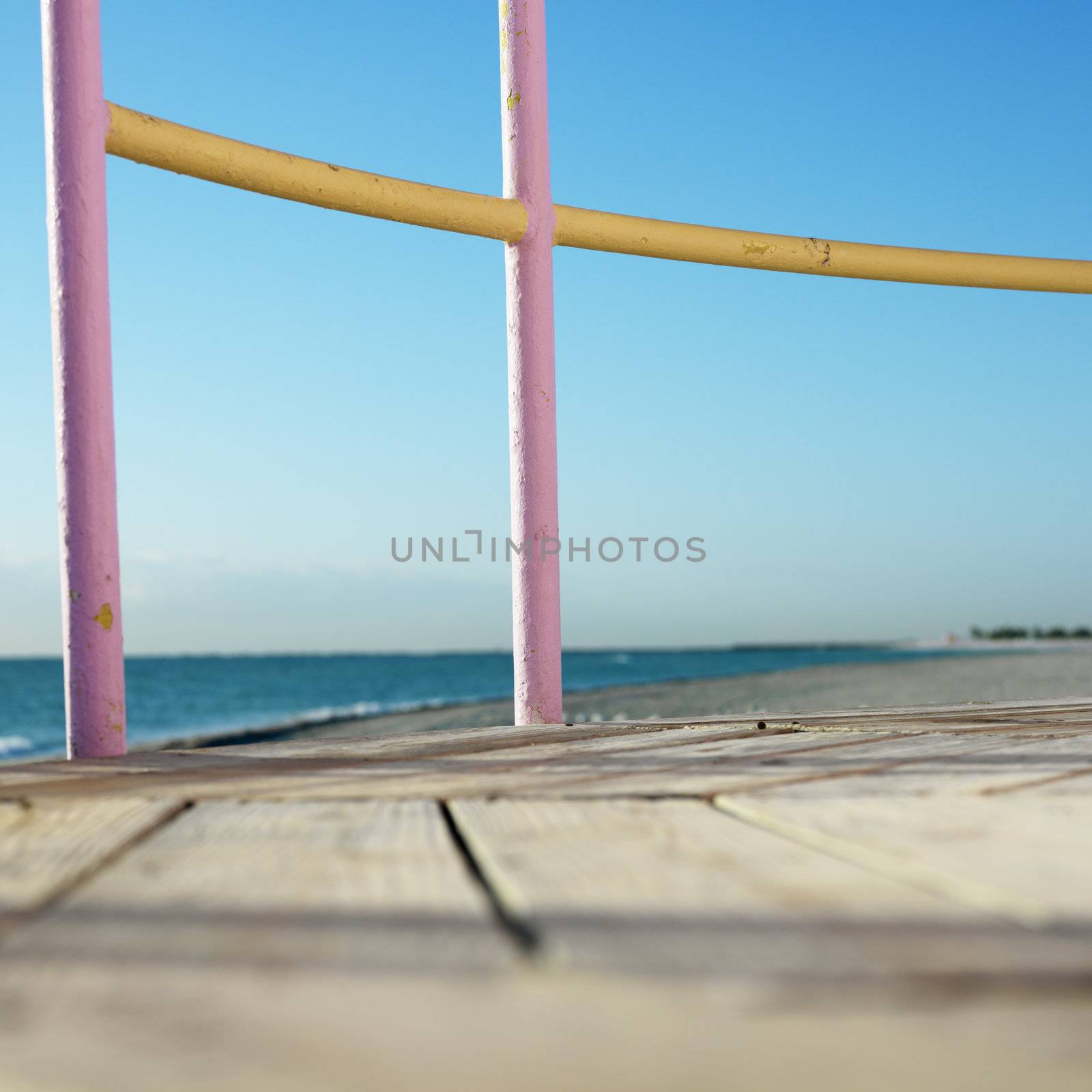 Pink and yellow painted railings of lifeguard tower on beach in Miami, Florida, USA.