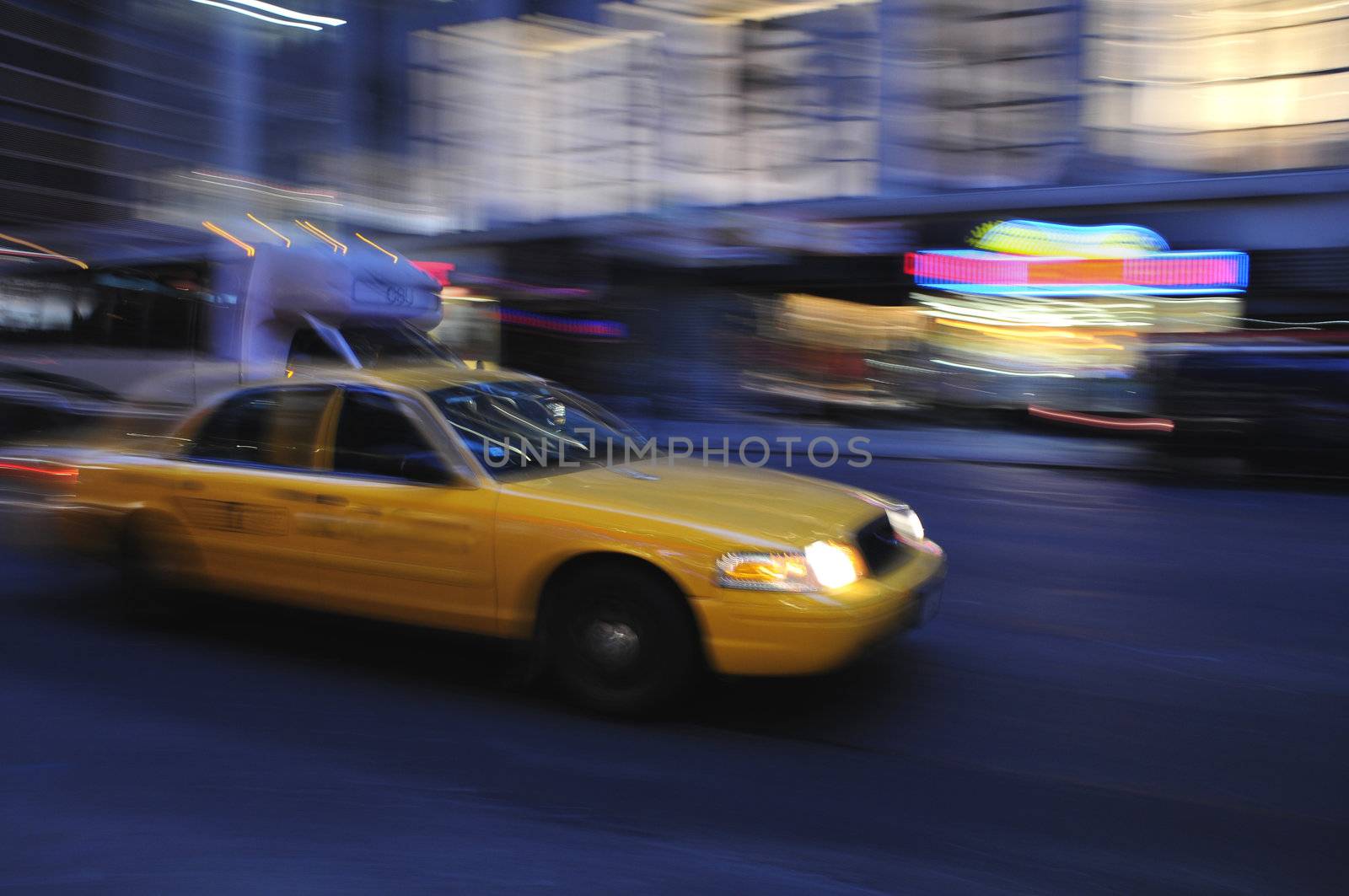 Taxi cab speeding down a city street at night by Balefire9