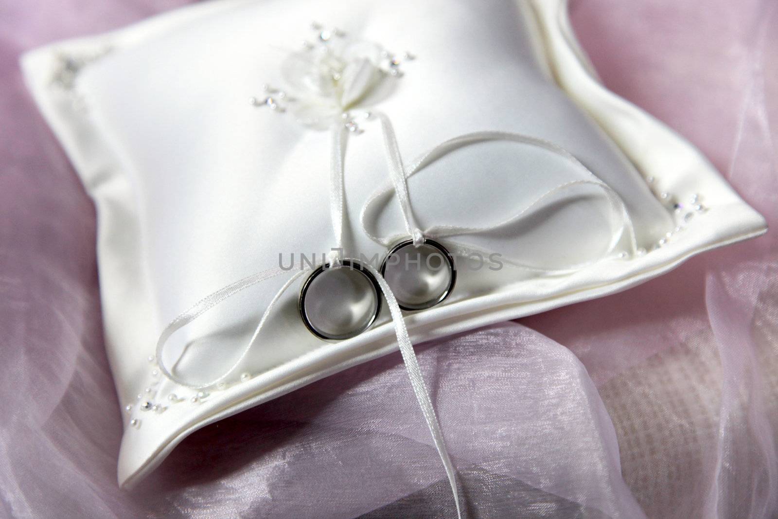 wedding rings on a white ring pillow - close-up