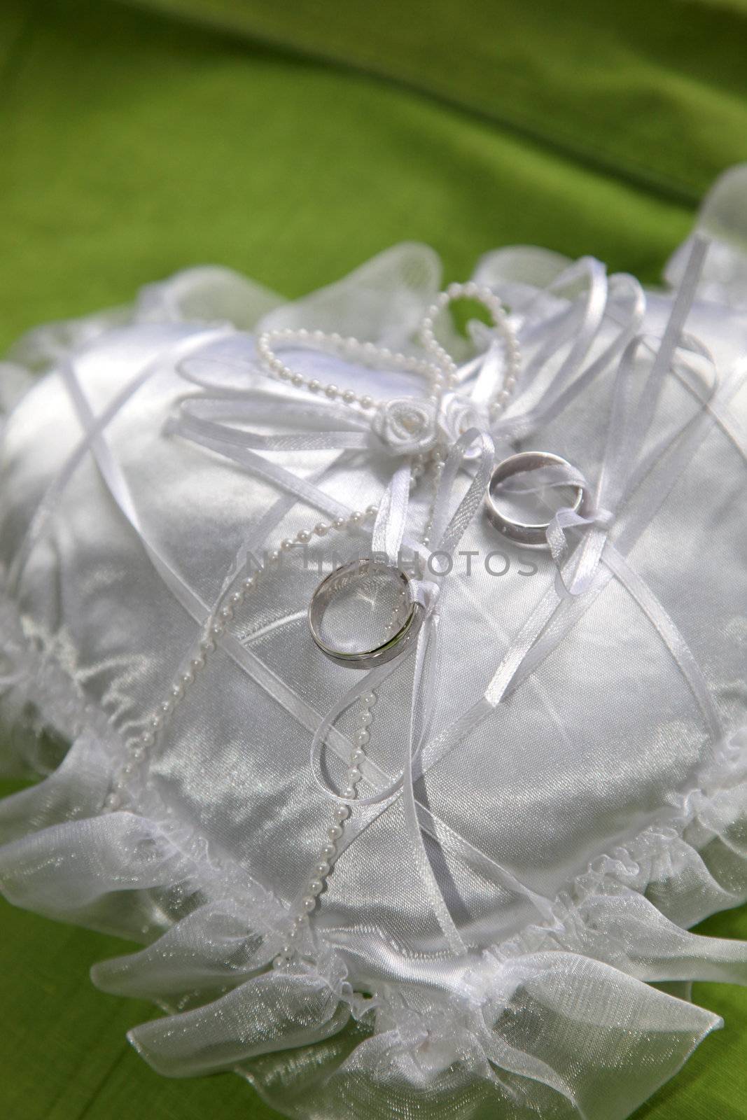 wedding rings on a white ring pillow - close-up