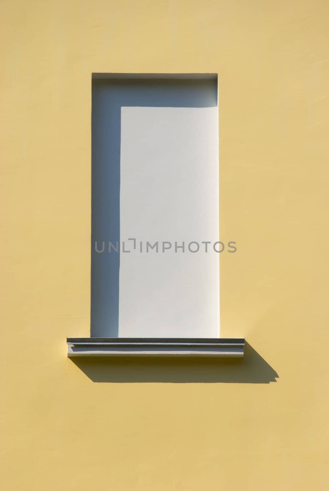The window is immure in yellow wall