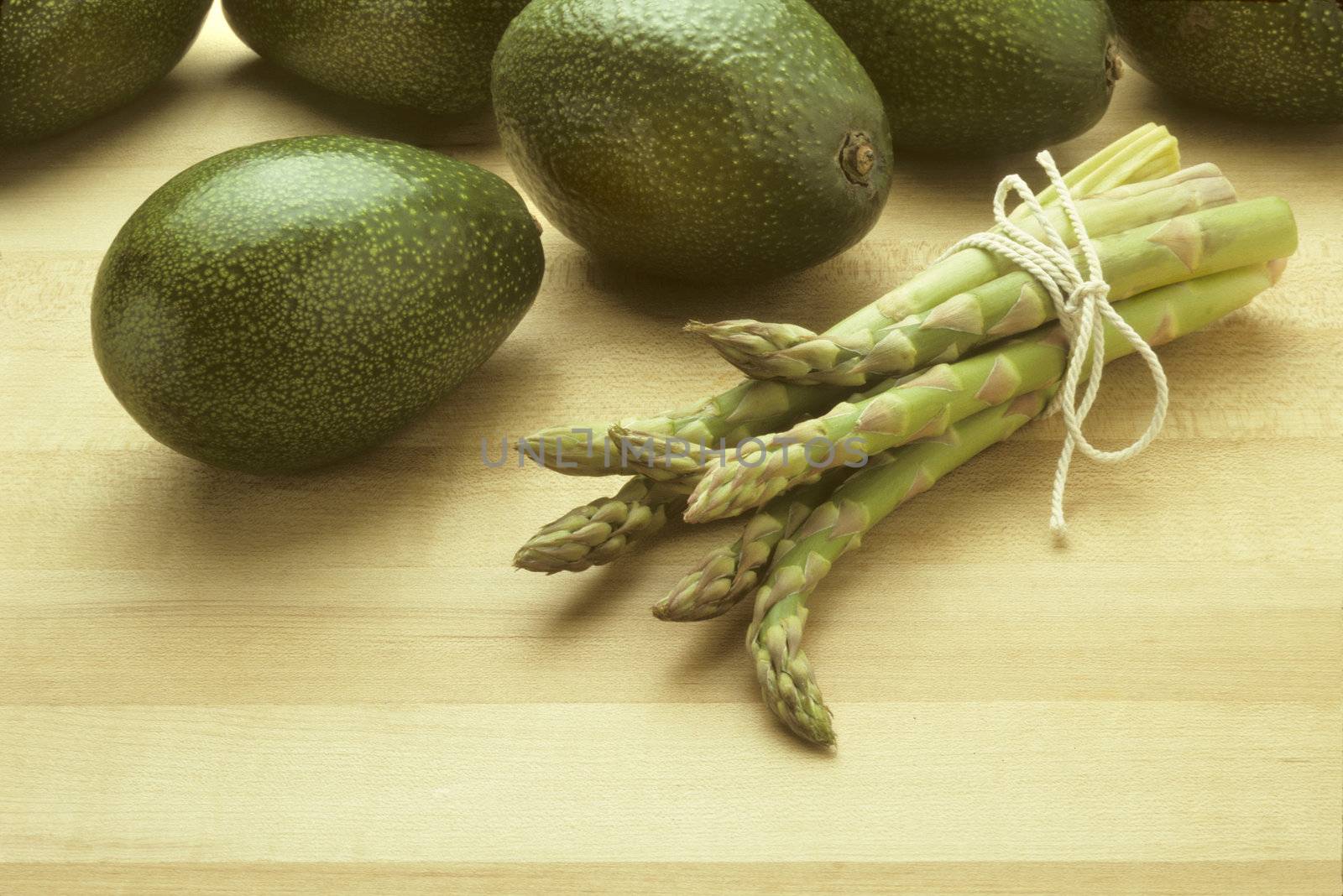 Avocados and asparagus on butcher block by Balefire9