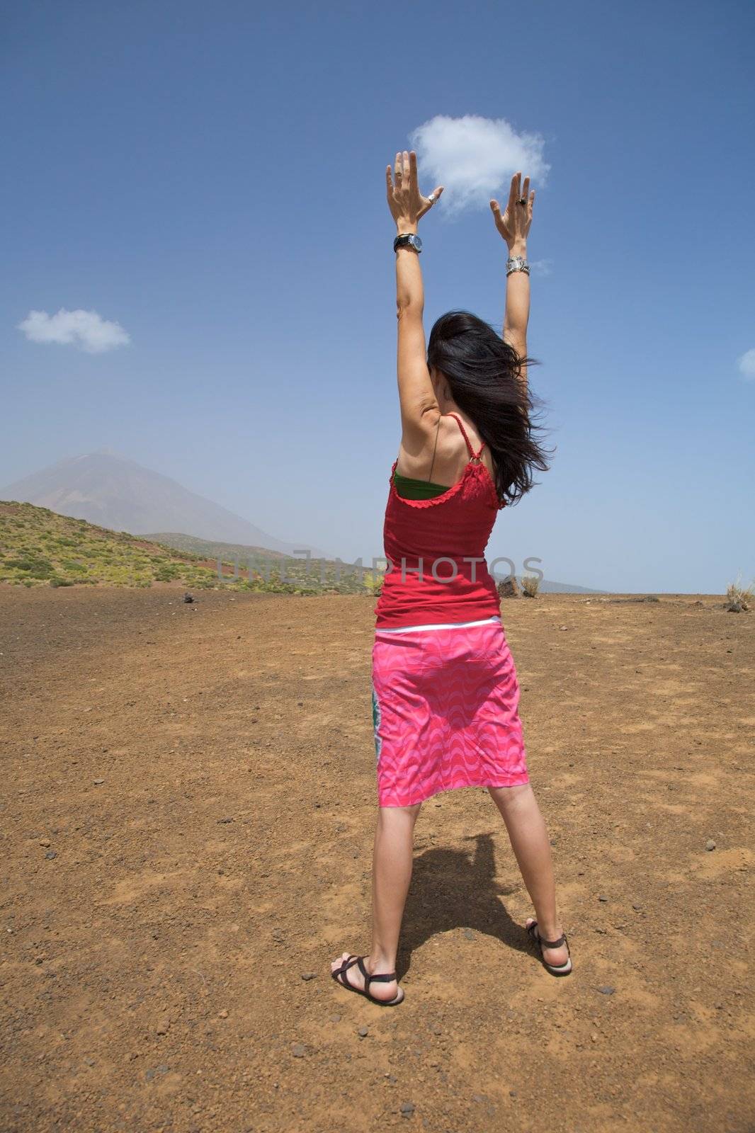woman catching a cloud with the teide volcano at the background