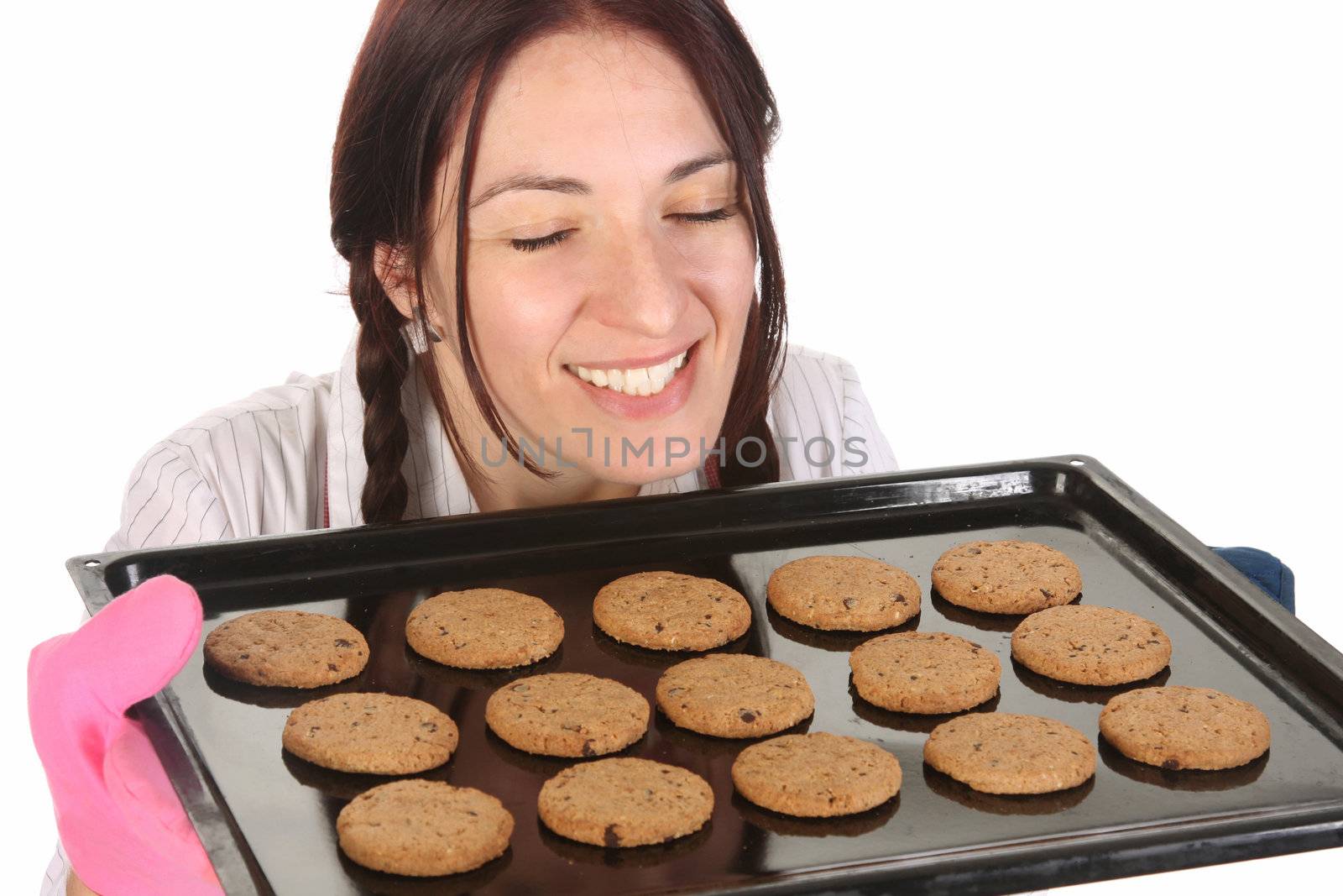 beautiful housewife smelling of cakes on white background