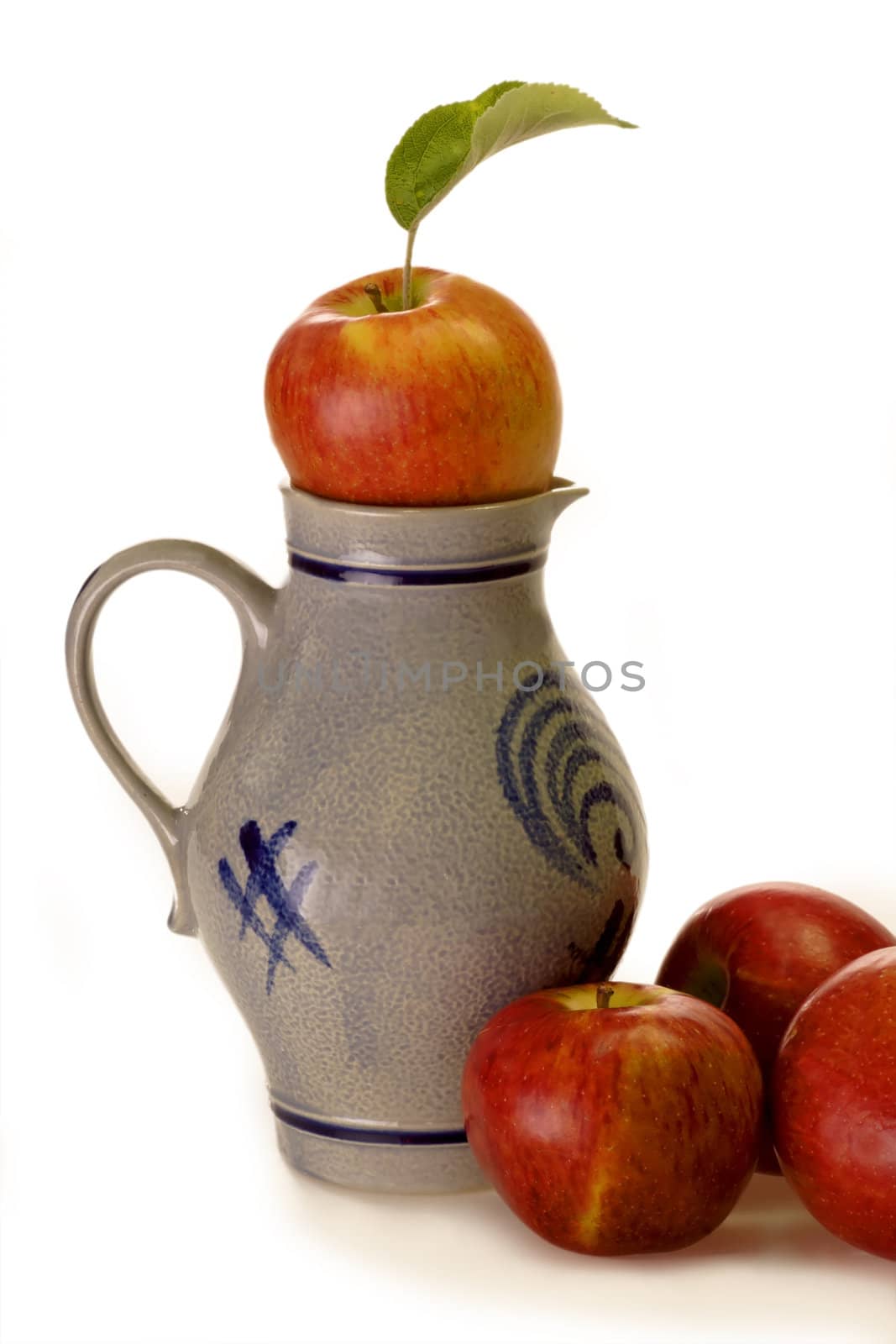Jug of apple wine and apples on bright background