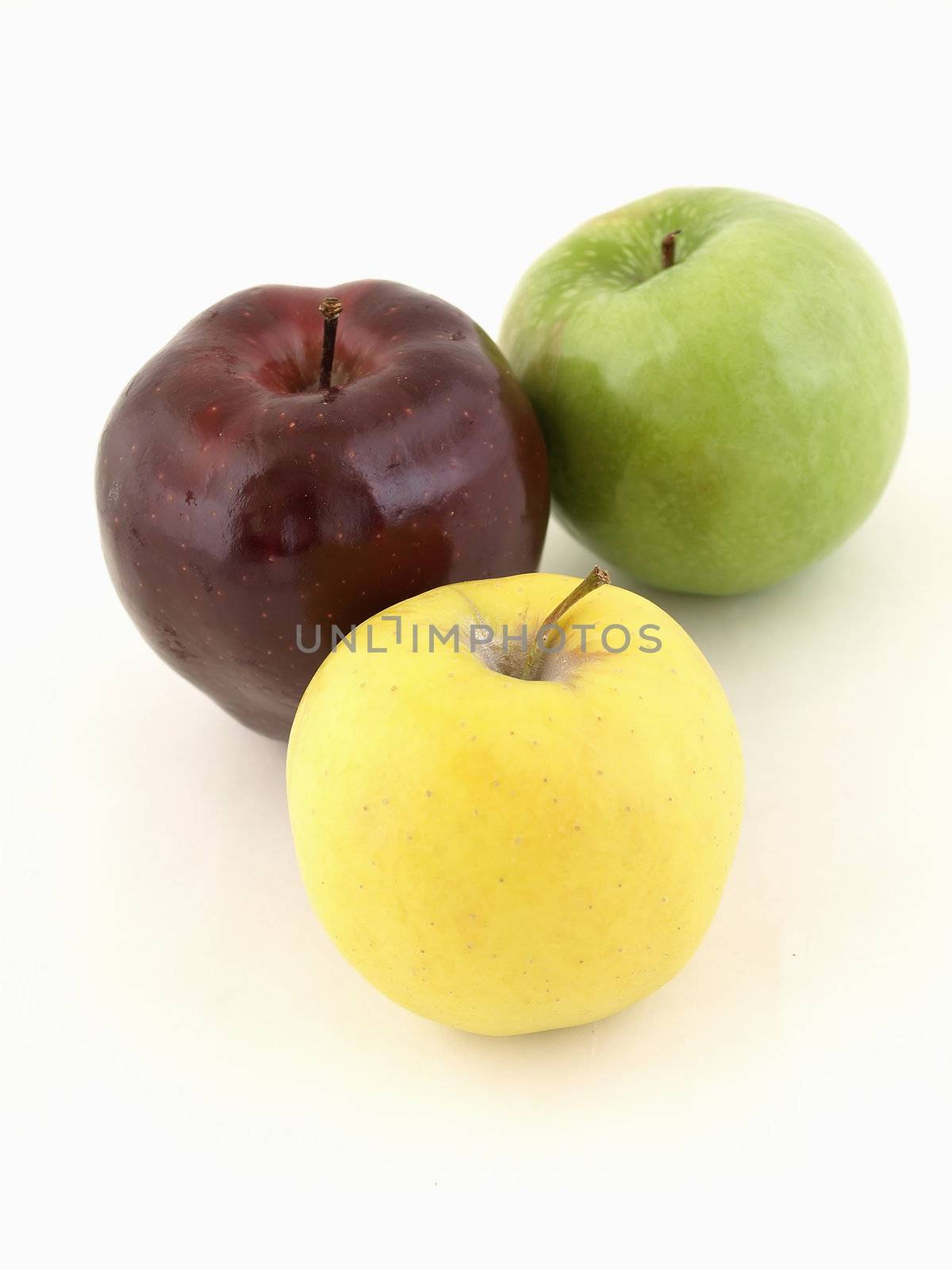 Three different colored apples in a grouping isolated on a white background