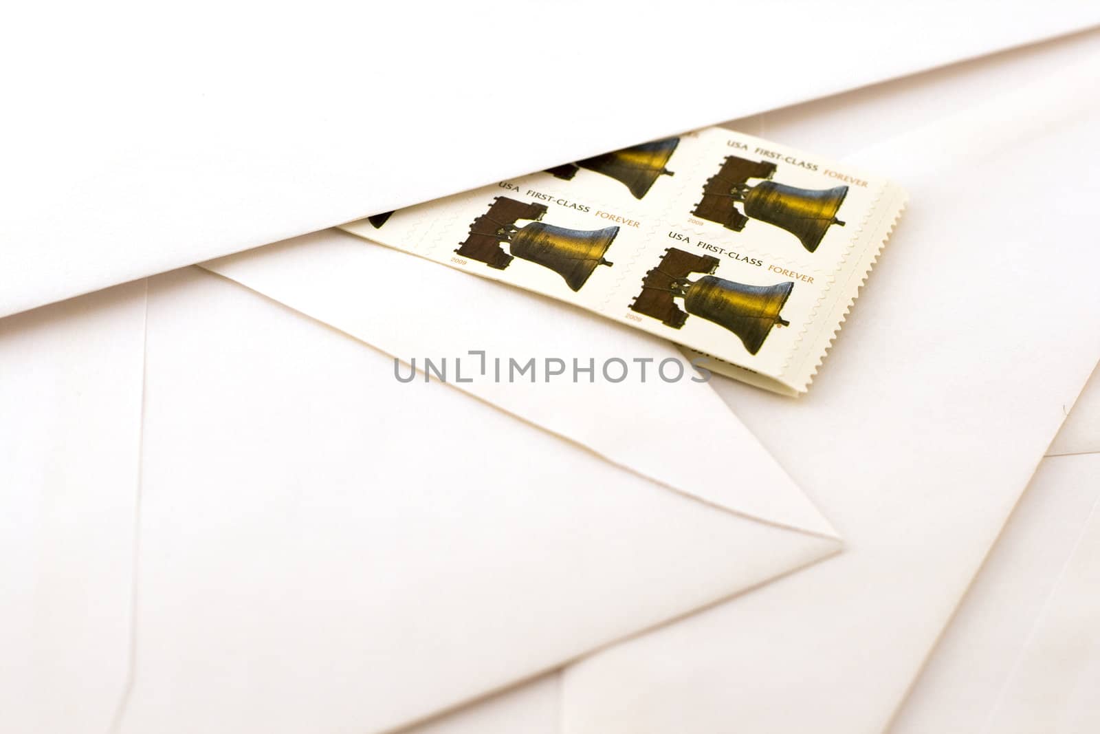 forever stamps against white envelopes