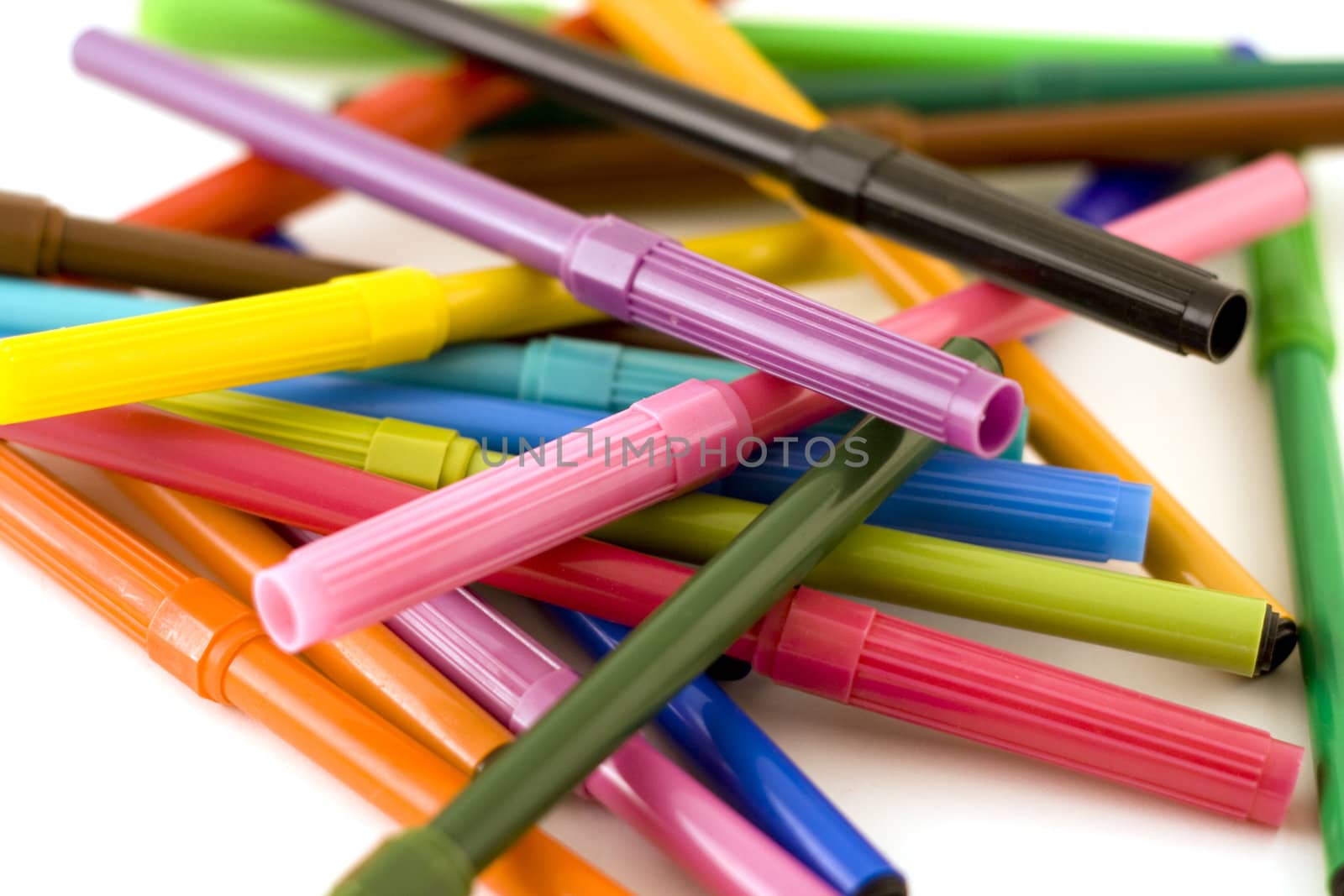 Pile of colorful markers on white background with shallow dof