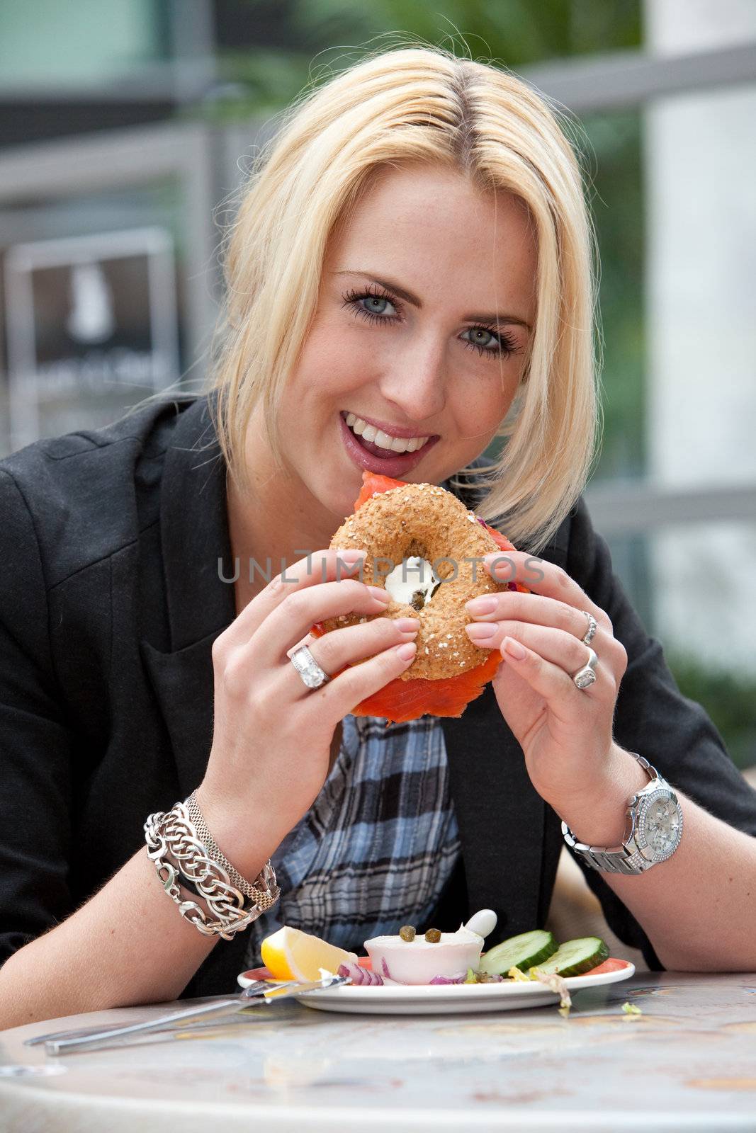 Pretty young girl eating a salmon bagel with creamcheese