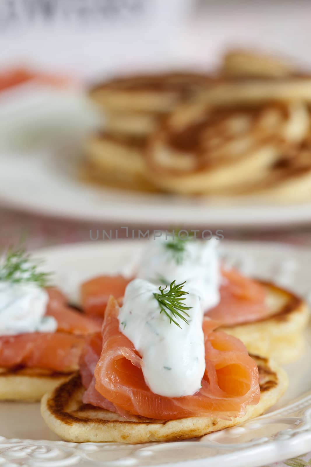 Delicious appetizer with a small pancake, salmon and sourcream