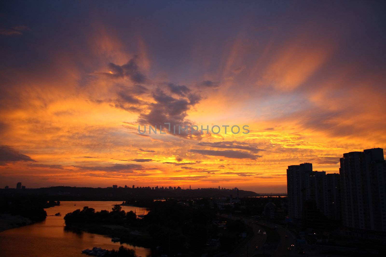 Silhouettes of the buildings and sunset rays in the sky.