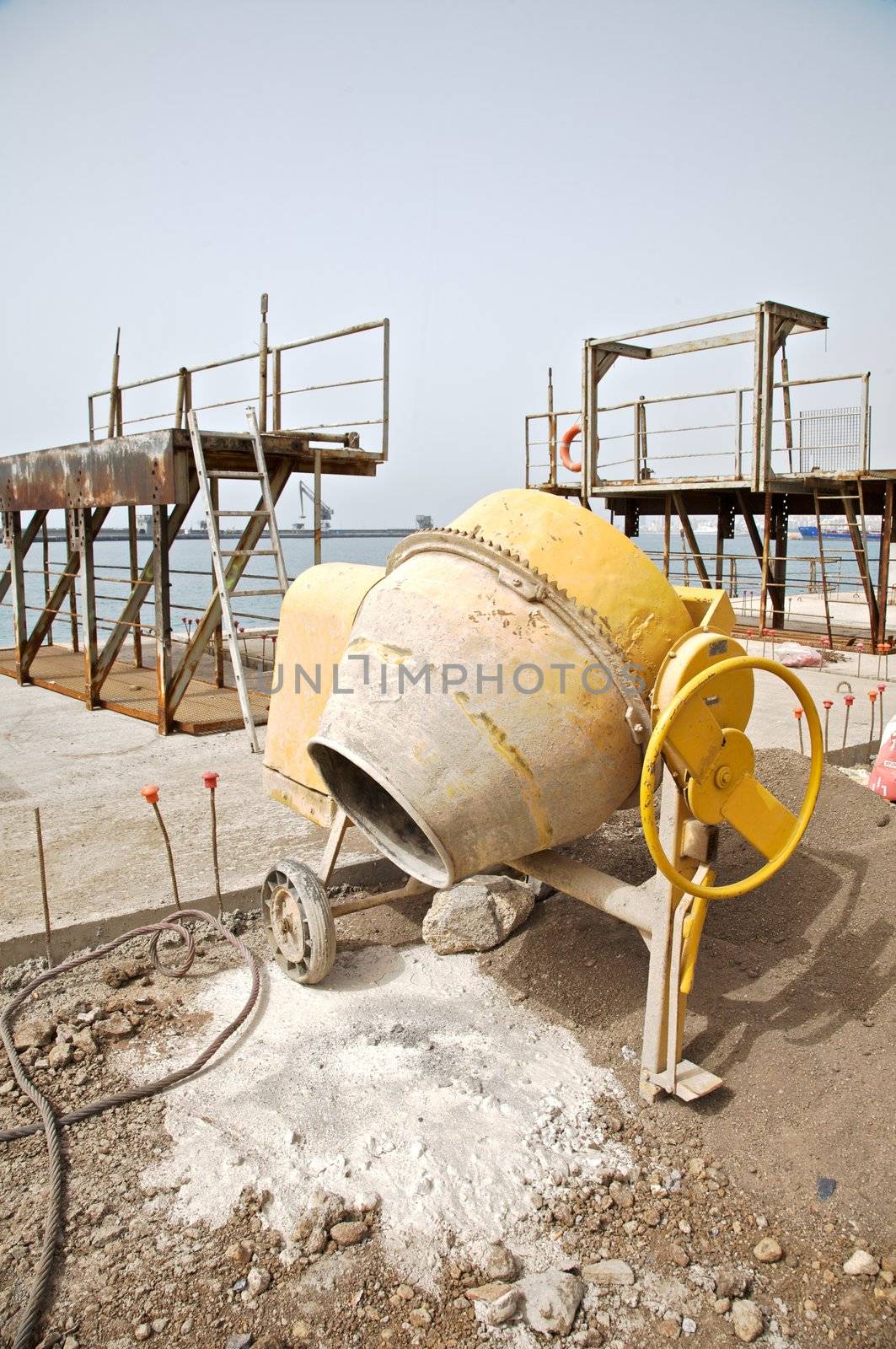 side view of a yellow working cement mixer
