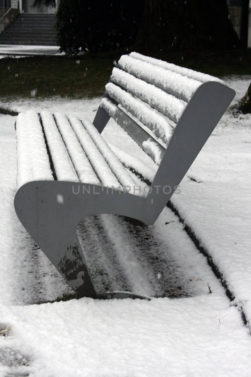 snow covered park bench by keki