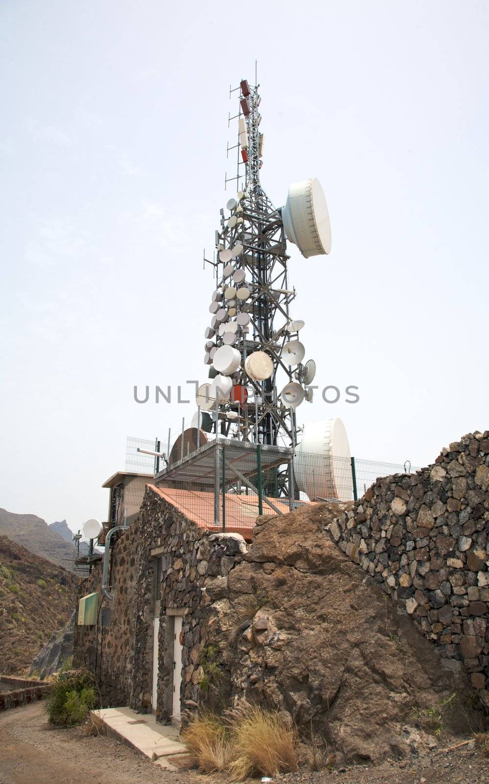 Communications antenna on the roof of a stone house