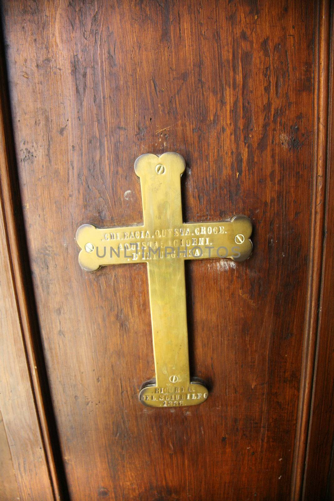 golden write cross on an old wood door