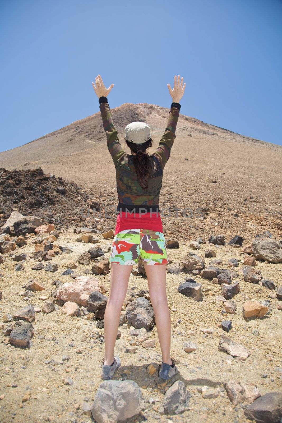 woman arms up the teide volcano in tenerife spain