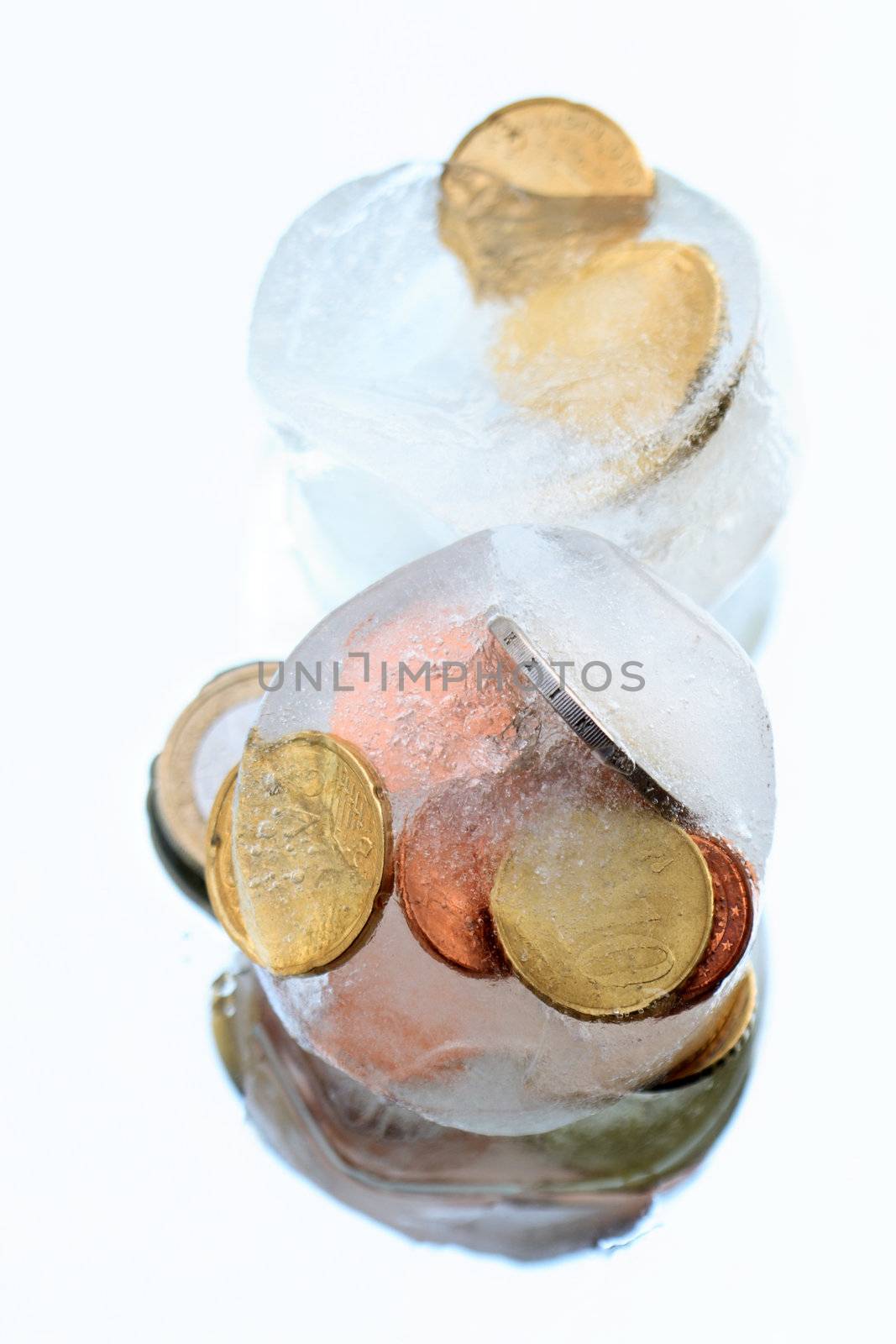 Coins inside ice cubes isolated on blue background