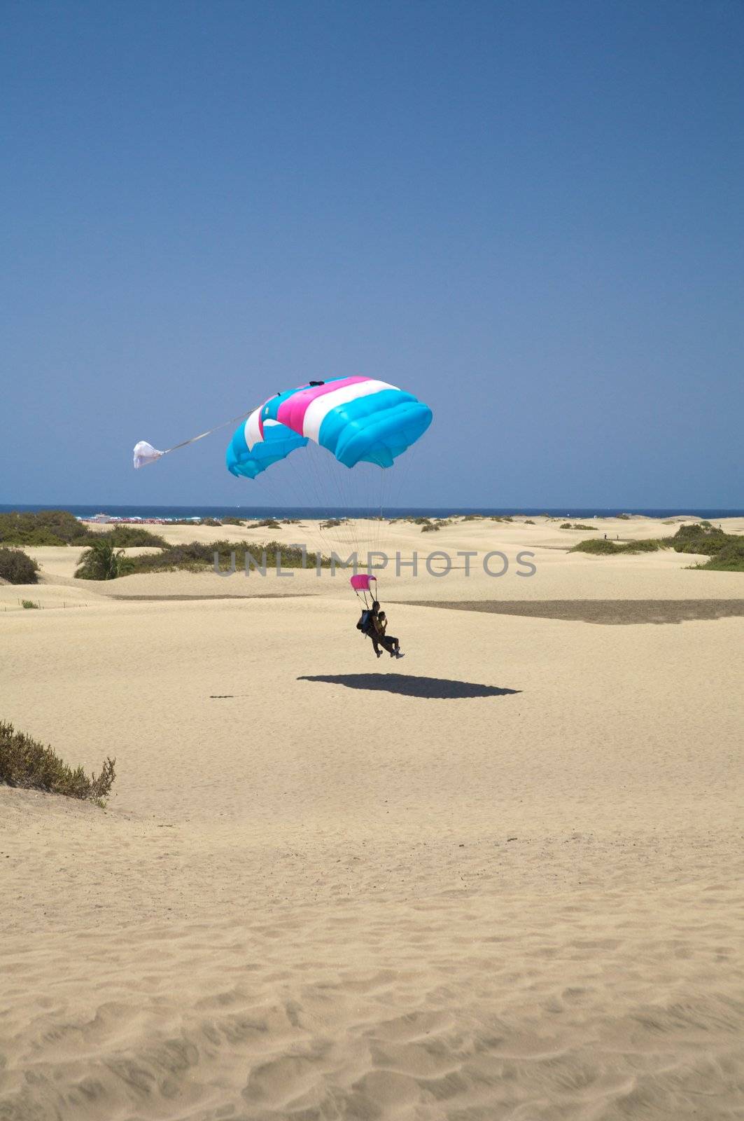 paraglider with a couple landing at the beach of Canary Islands spain