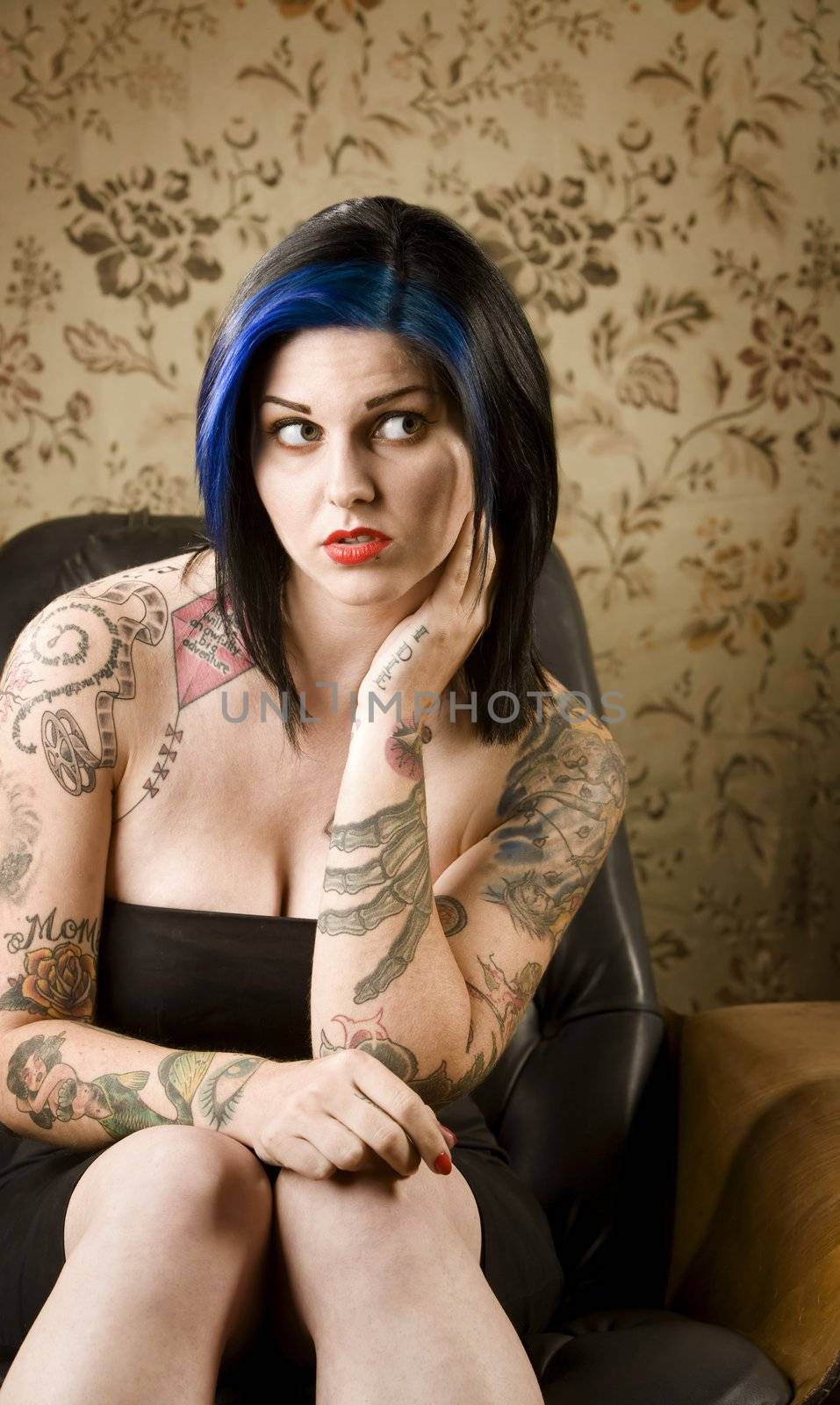 Pretty Woman with Tattoos in a Leather Chair by Creatista