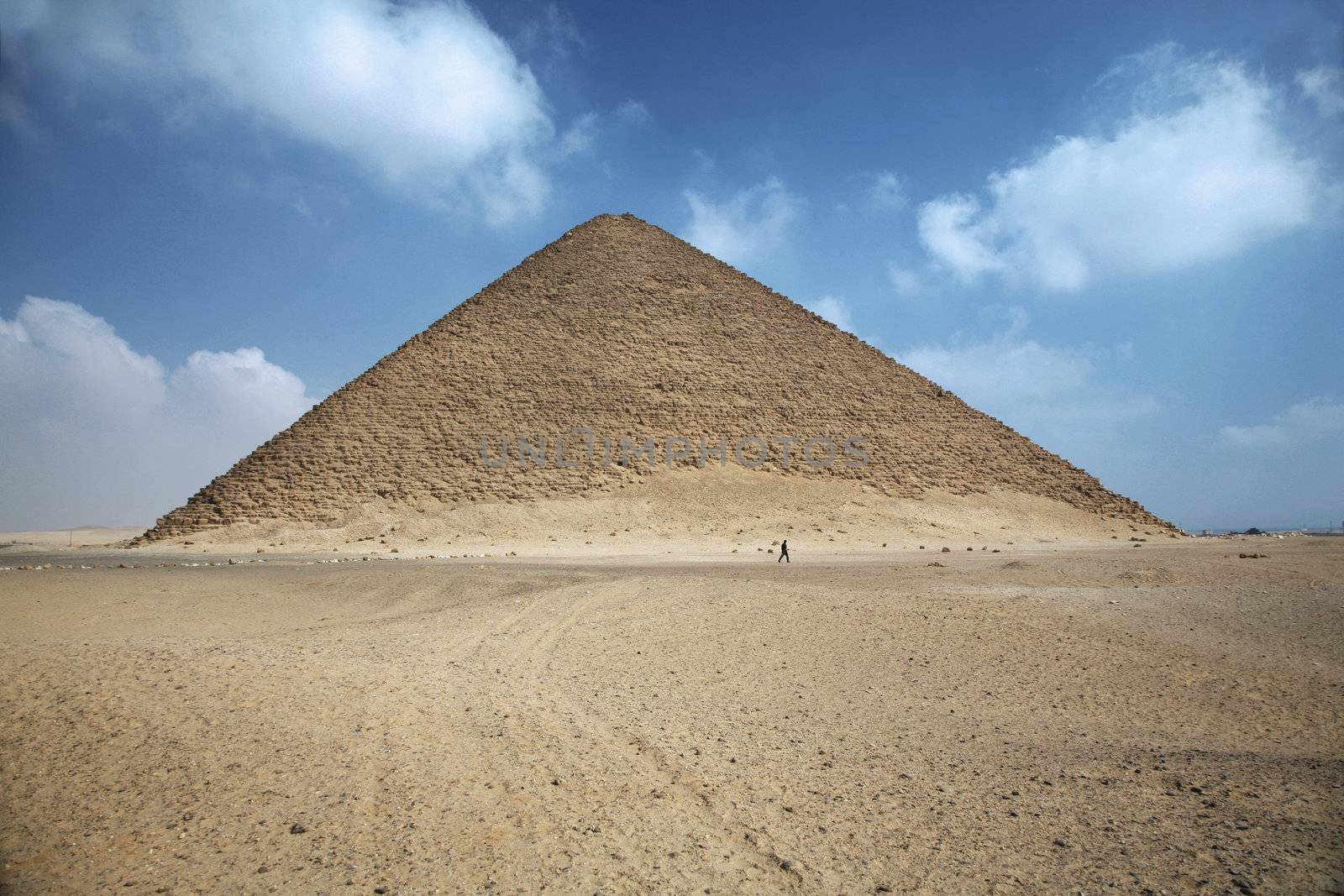 a man walking next red pyramid in egypt