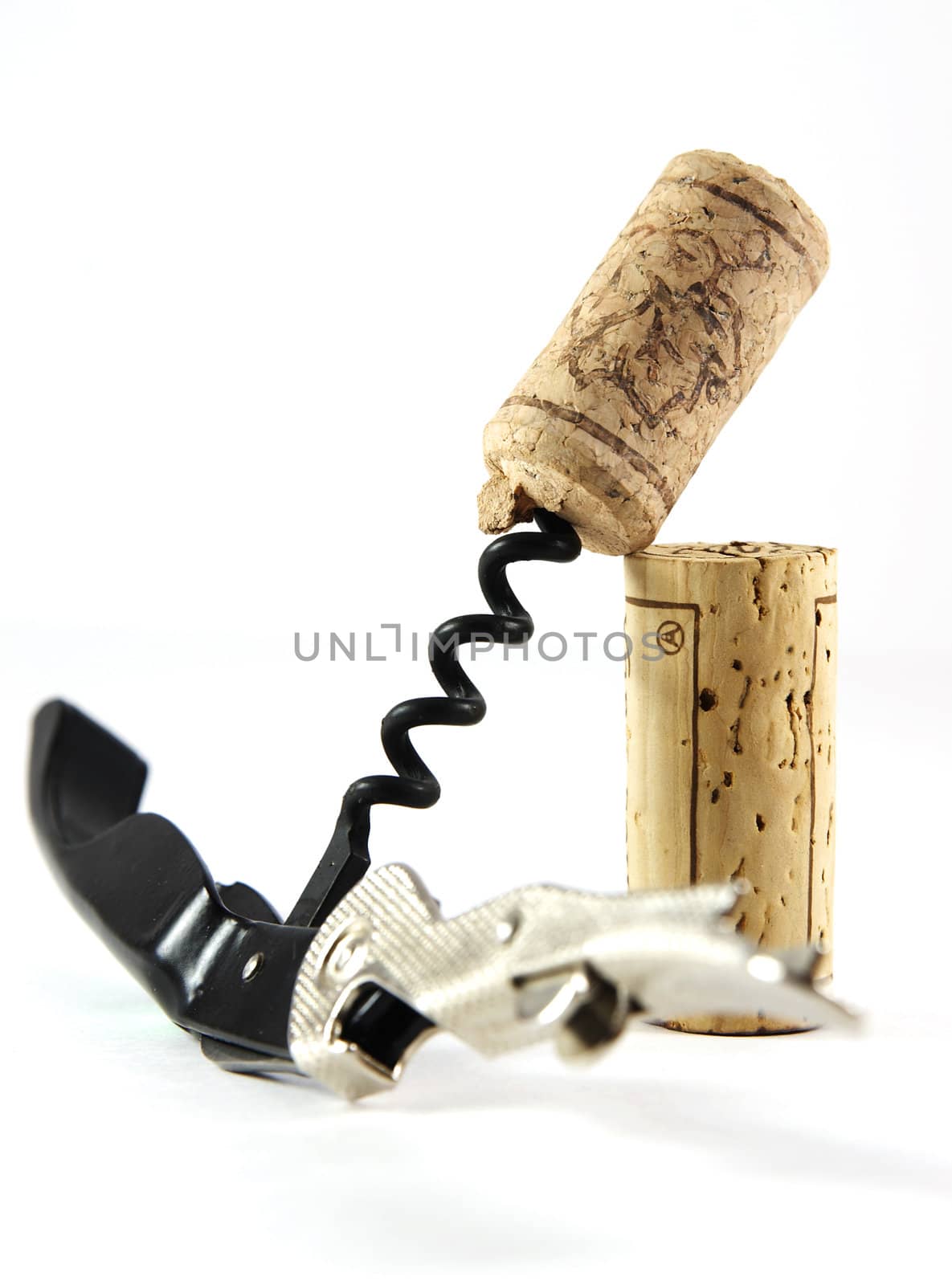 Corkscrew and two corks isolated over white background