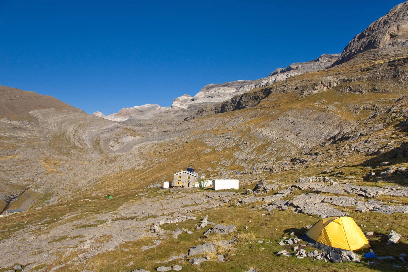 Yellow tent and in background refuge Goriz and monte Perdido massif. Ordesa National Park - Spain.