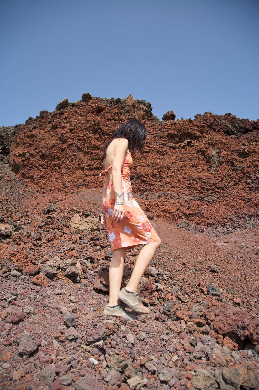 woman walking on volcanic rocks in tenerife spain
