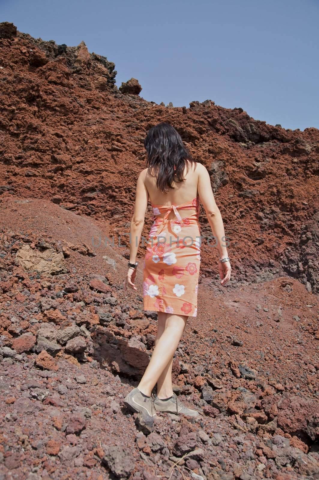 woman walking on volcanic rocks in tenerife spain