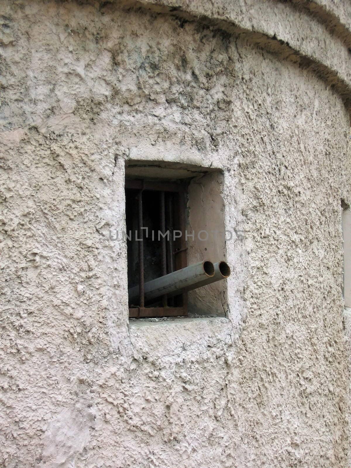 Gun is in the window of a stone fortress