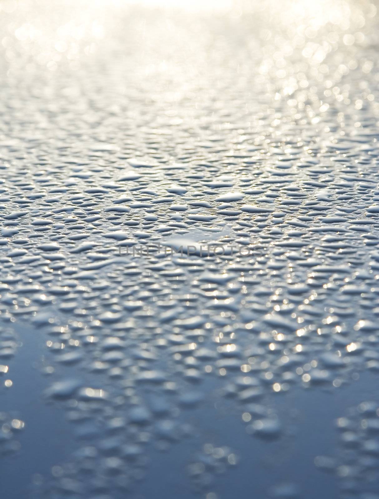 Water droplets on a metallic car paint.